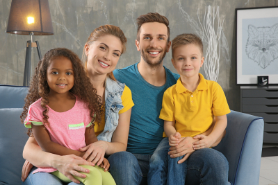 happy interracial family sitting on sofa